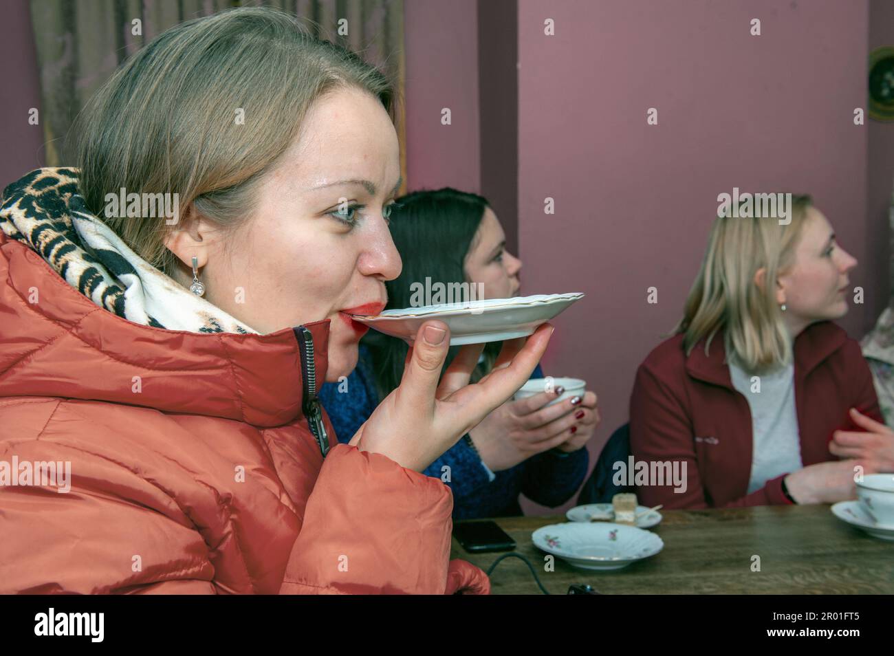 Tea drinking from a saucer, an old Russian tradition. A woman drinks