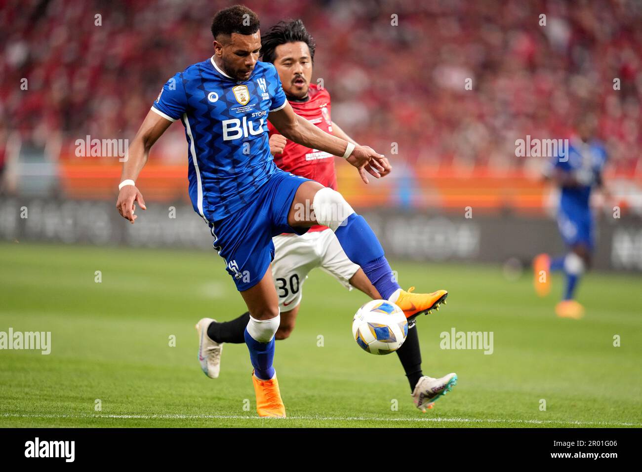 Al Hilal's Ali Al Bulayhi, right, fights for the ball with Urawa