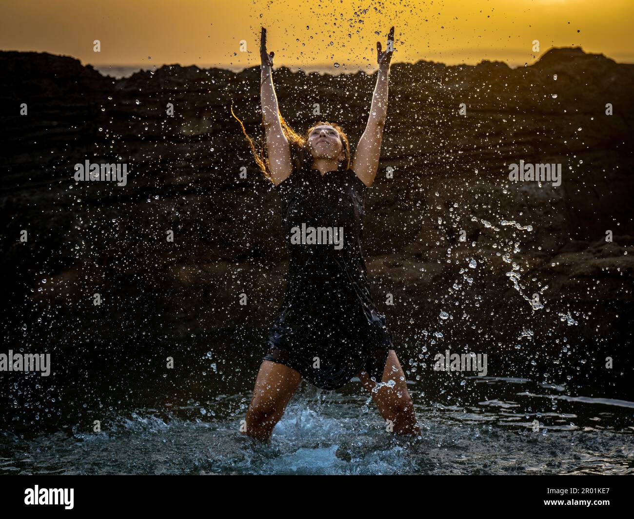 middle-aged woman dancing and throwing water in the air, Maioris beach, llucmajor, Majorca, Balearic Islands, Spain. Stock Photo