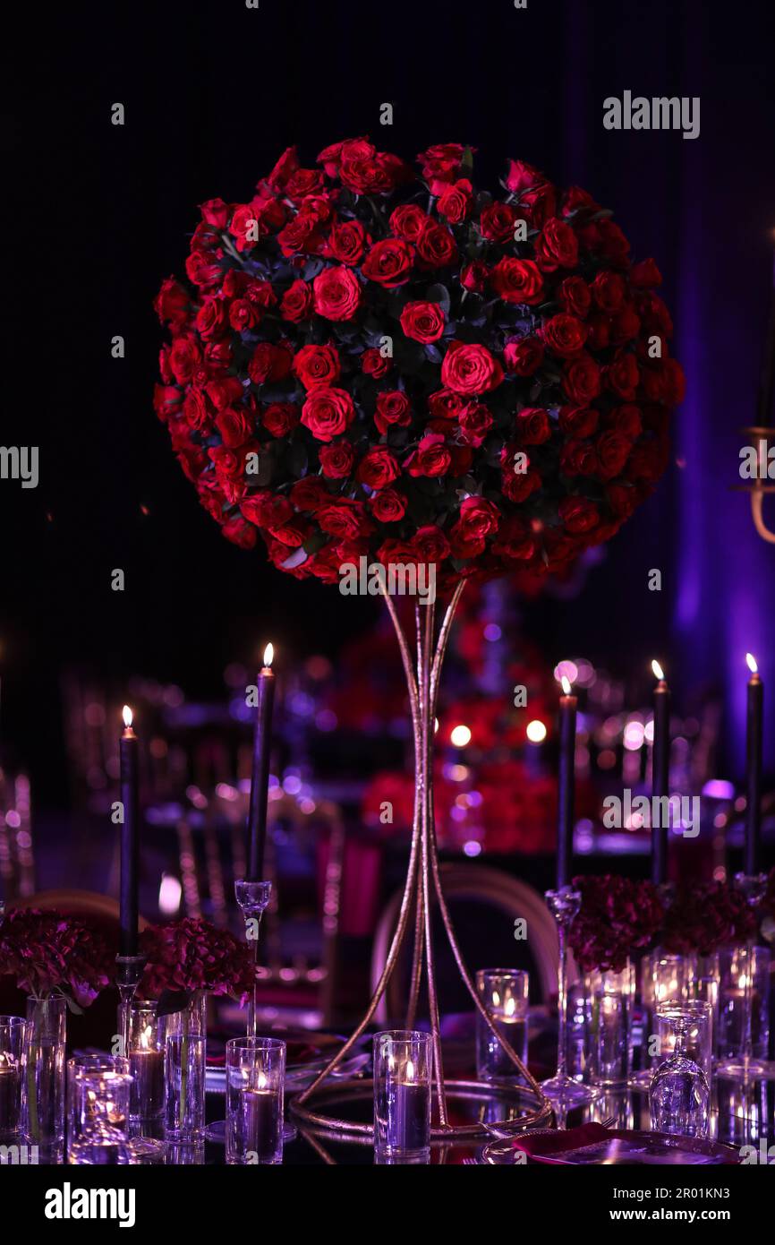 A beautiful bouquet of red roses arranged in a centerpiece at a wedding ...