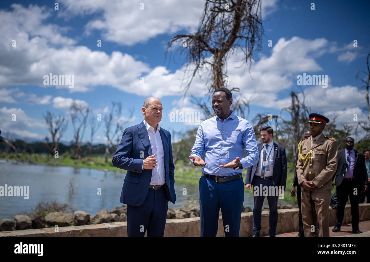 Olkaria, Kenya. 06th May, 2023. German Chancellor Olaf Scholz (SPD, l) listens to hydrologist Luke Olang explain the ecological and economic changes at Sopa Lodge on Lake Naivasha. The visit is the last item on the chancellor's three-day trip to Africa. Credit: Michael Kappeler/dpa/Alamy Live News Stock Photo