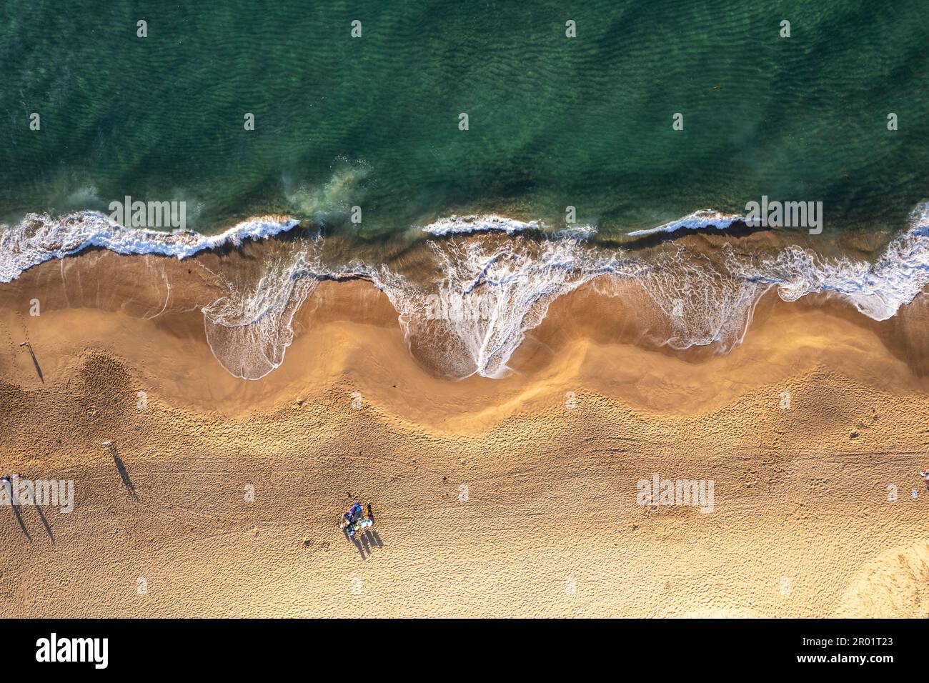 An aerial view of Stanwell Beach surrounded by the sea during the sunrise in Australia Stock Photo