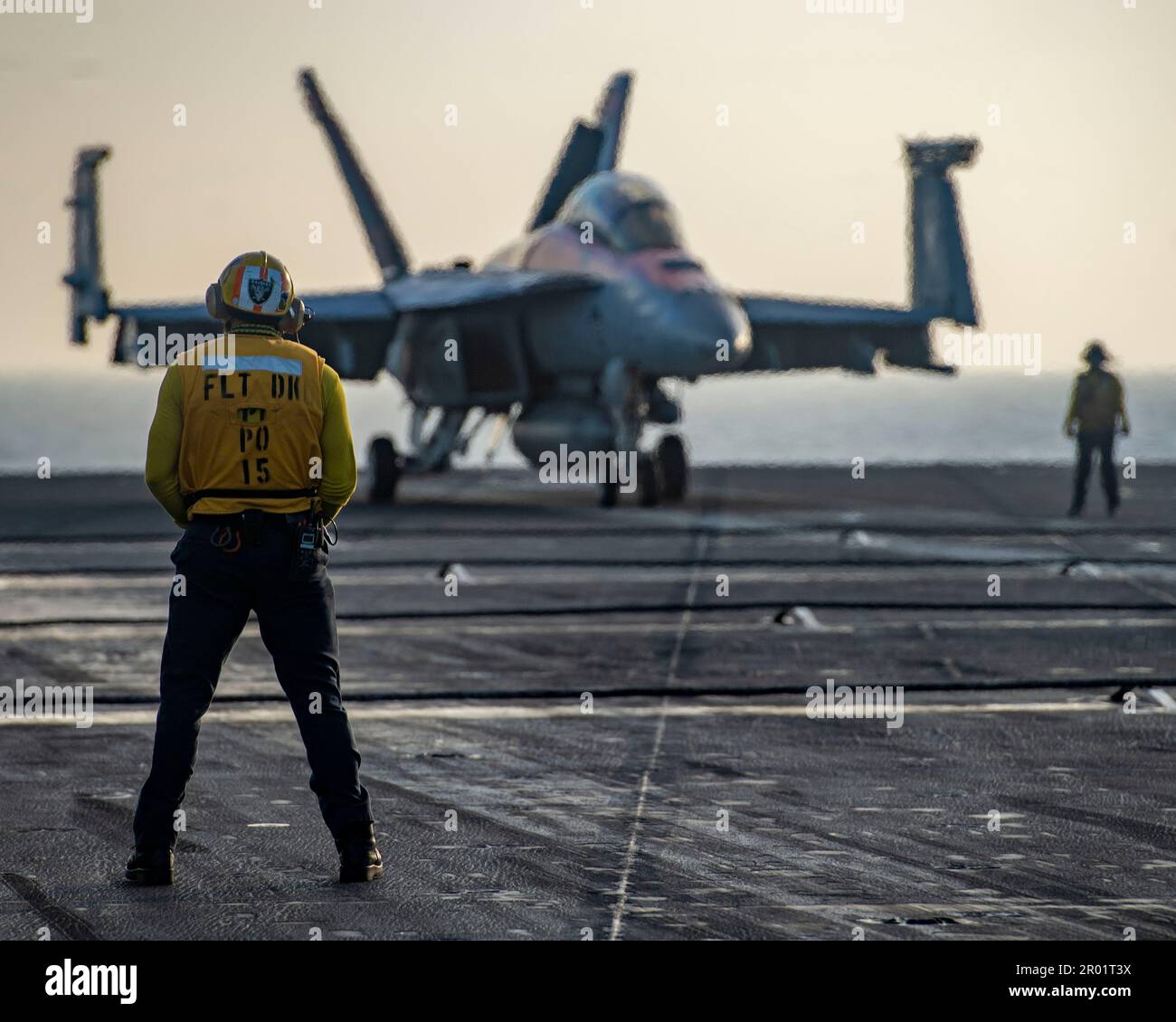 USS Nimitz, International Waters. 01 May, 2023. A U.S. Navy flight deck crew sailor watches a F/A-18F Super Hornet fighter aircraft from the Mighty Shrikes of Strike Fighter Squadron 94, taxi on the flight deck of the Nimitz-class aircraft carrier USS Nimitz underway conducting routine operations, May 1, 2023 in the South China Sea.  Credit: MC2 Justin McTaggart/U.S Navy Photo/Alamy Live News Stock Photo