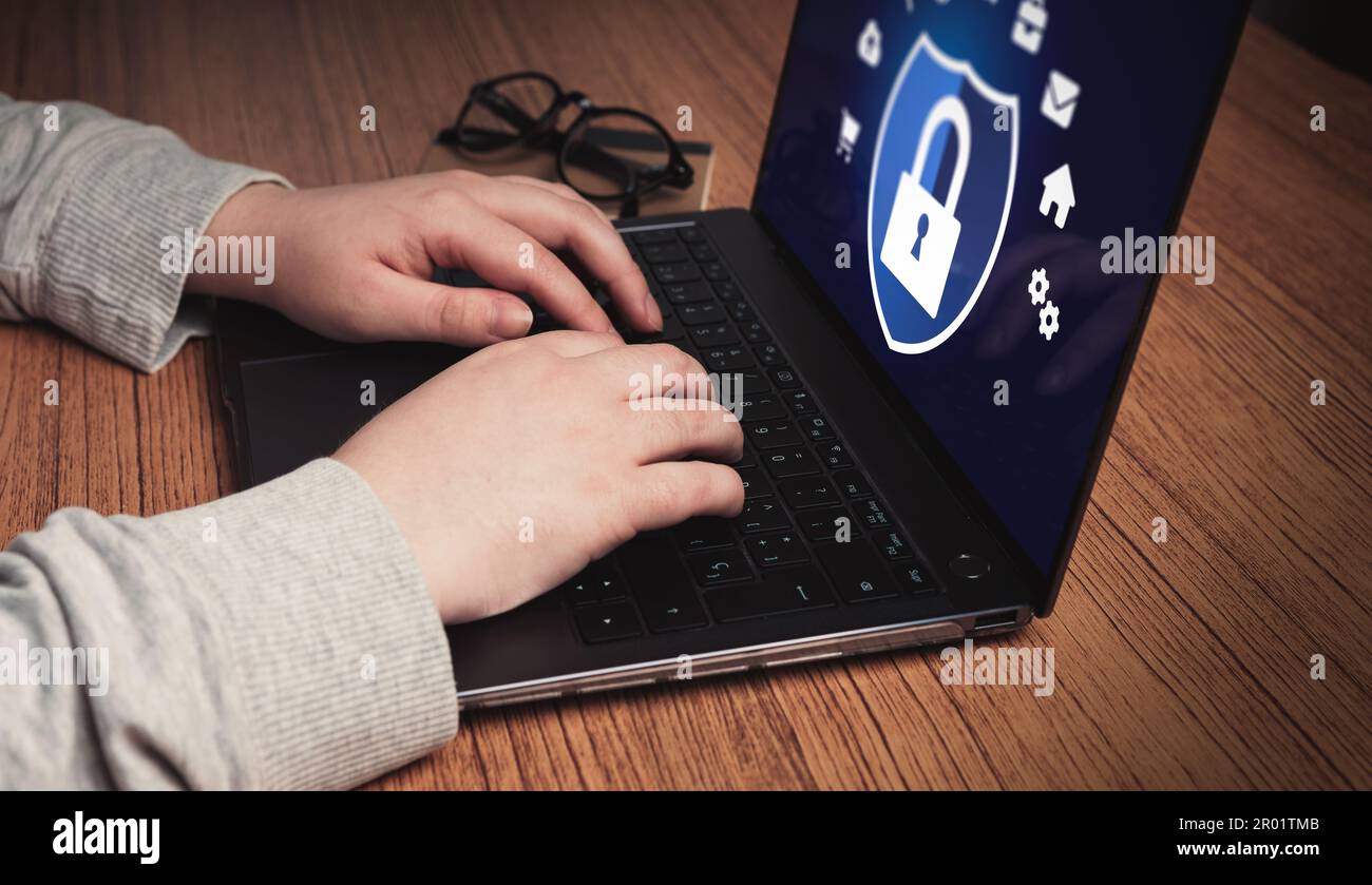 Woman use laptop with digital security interface. Cybersecurity concept. Icon shield with lock symbol. Protection against dangers. Stock Photo