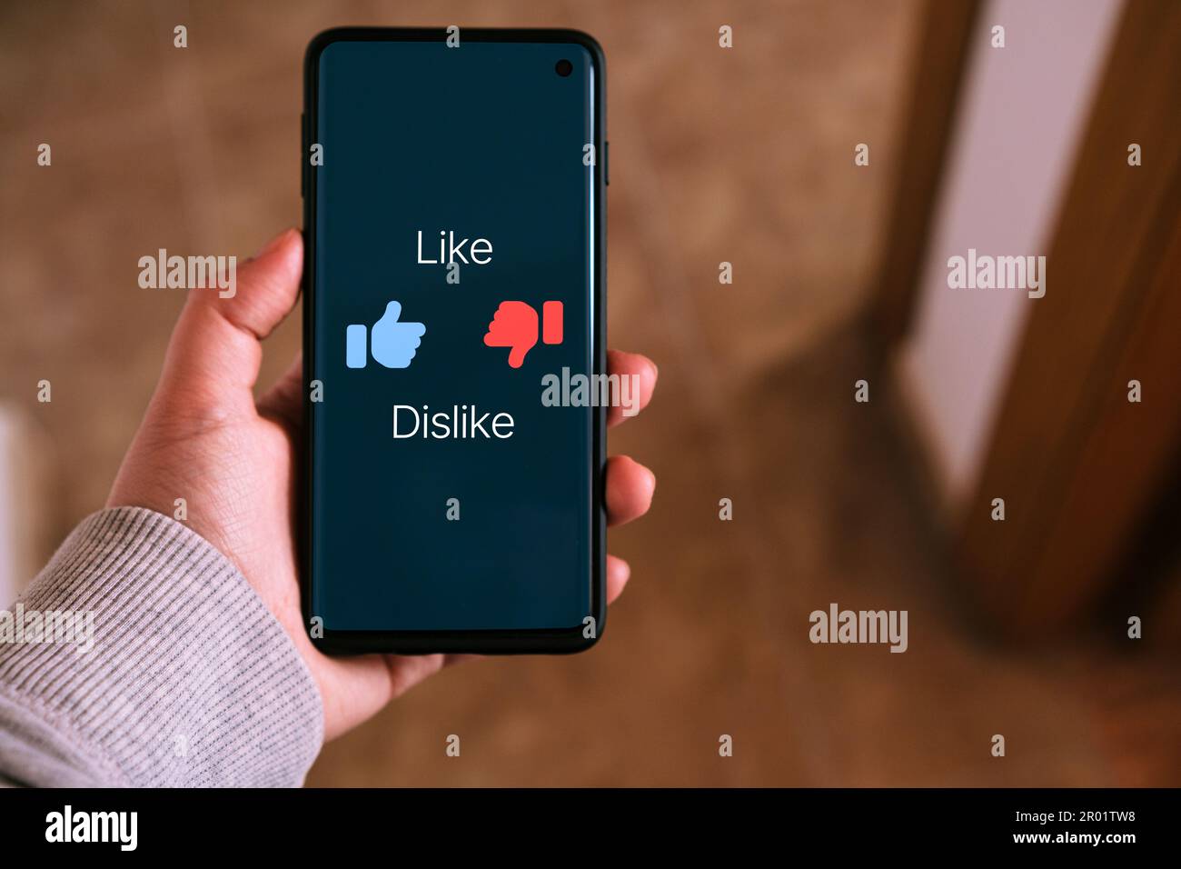 Woman use smartphone with a Like and Dislike symbols on screen. Social media concept. Feedback and review. Internet of things. Stock Photo