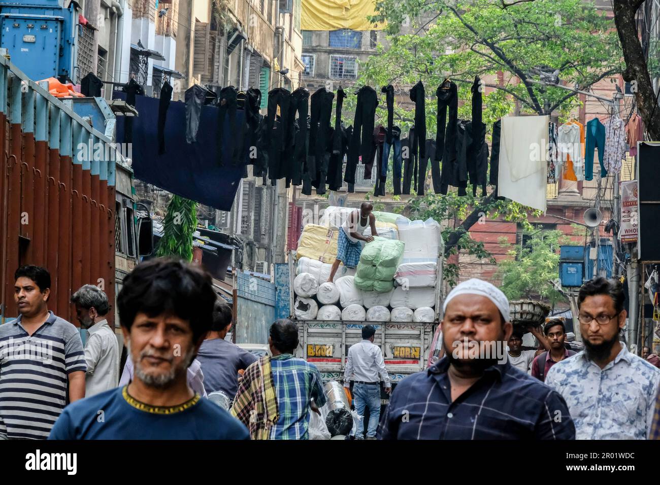 Kolkata, India. 22nd Mar, 2023. People walk on a busy street in Kolkata  while pants are being hanged above the street for drying purposes. (Credit  Image: © Dipayan Bose/SOPA Images via ZUMA
