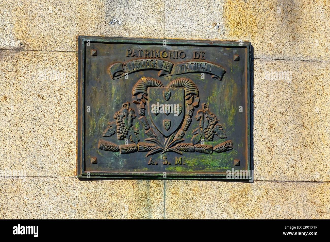Old historical plaque with a coat of arms and the text 'Patrimony' or heritage. Stock Photo