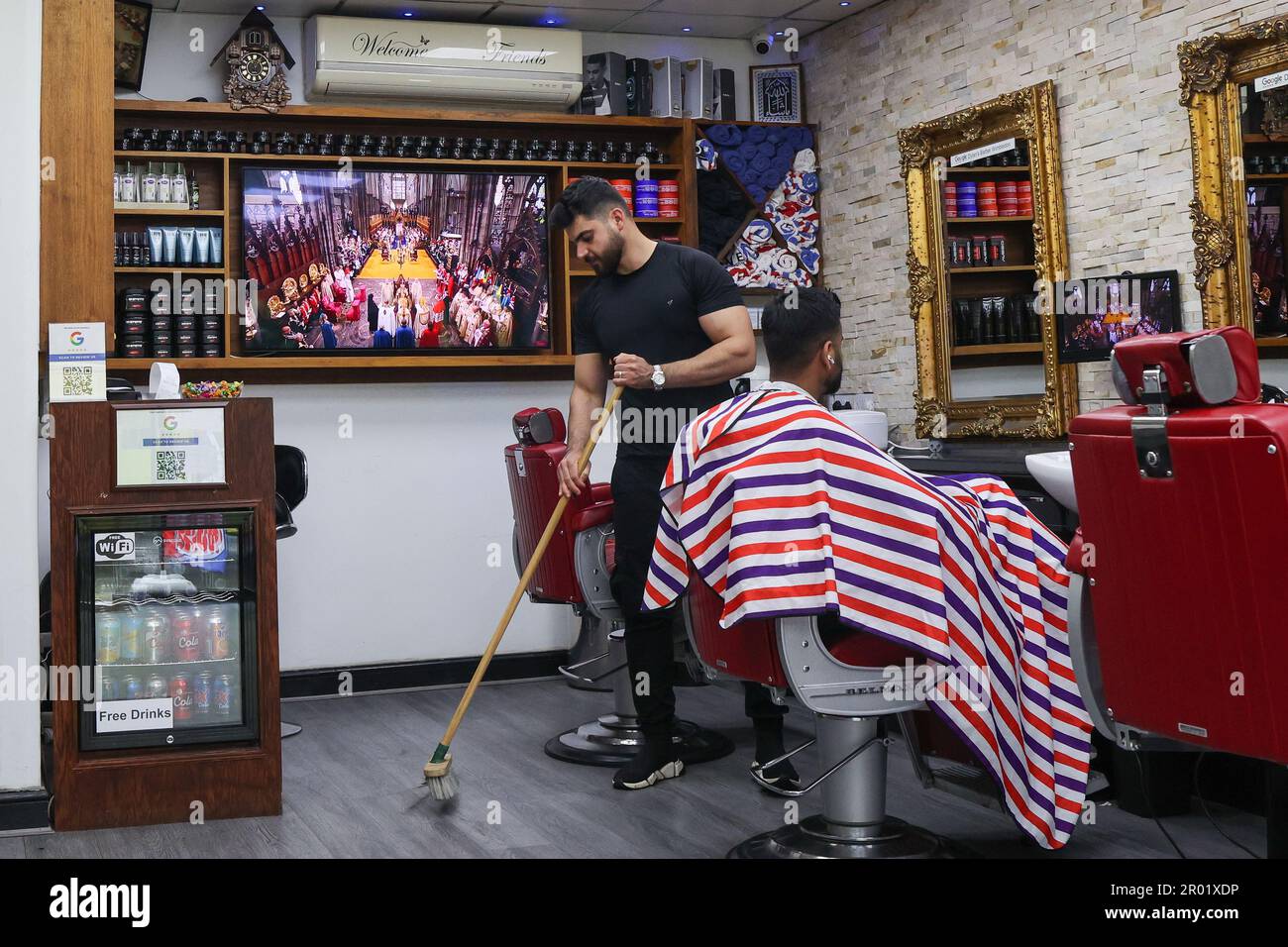 London, UK. May 6, 2023. A TV screen shows the  Coronation of King Charles III in Dylan’s Barbers, Wimbledon, London. Credit: Katie Collins/Alamy Live News Stock Photo