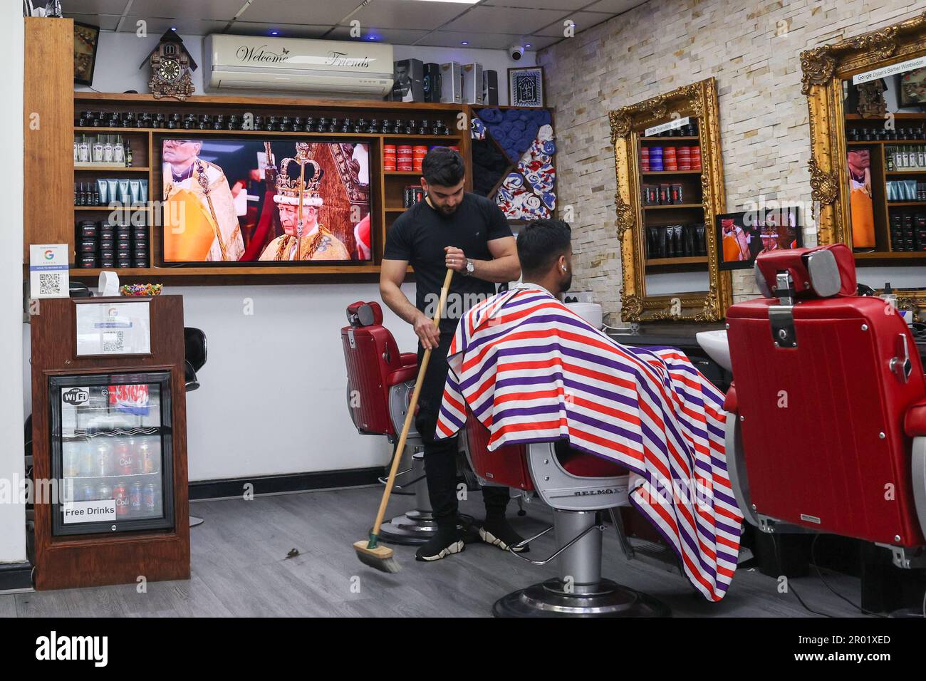 London, UK. May 6, 2023. A TV screen shows the  Coronation of King Charles III in Dylan’s Barbers, Wimbledon, London. Credit: Katie Collins/Alamy Live News Stock Photo