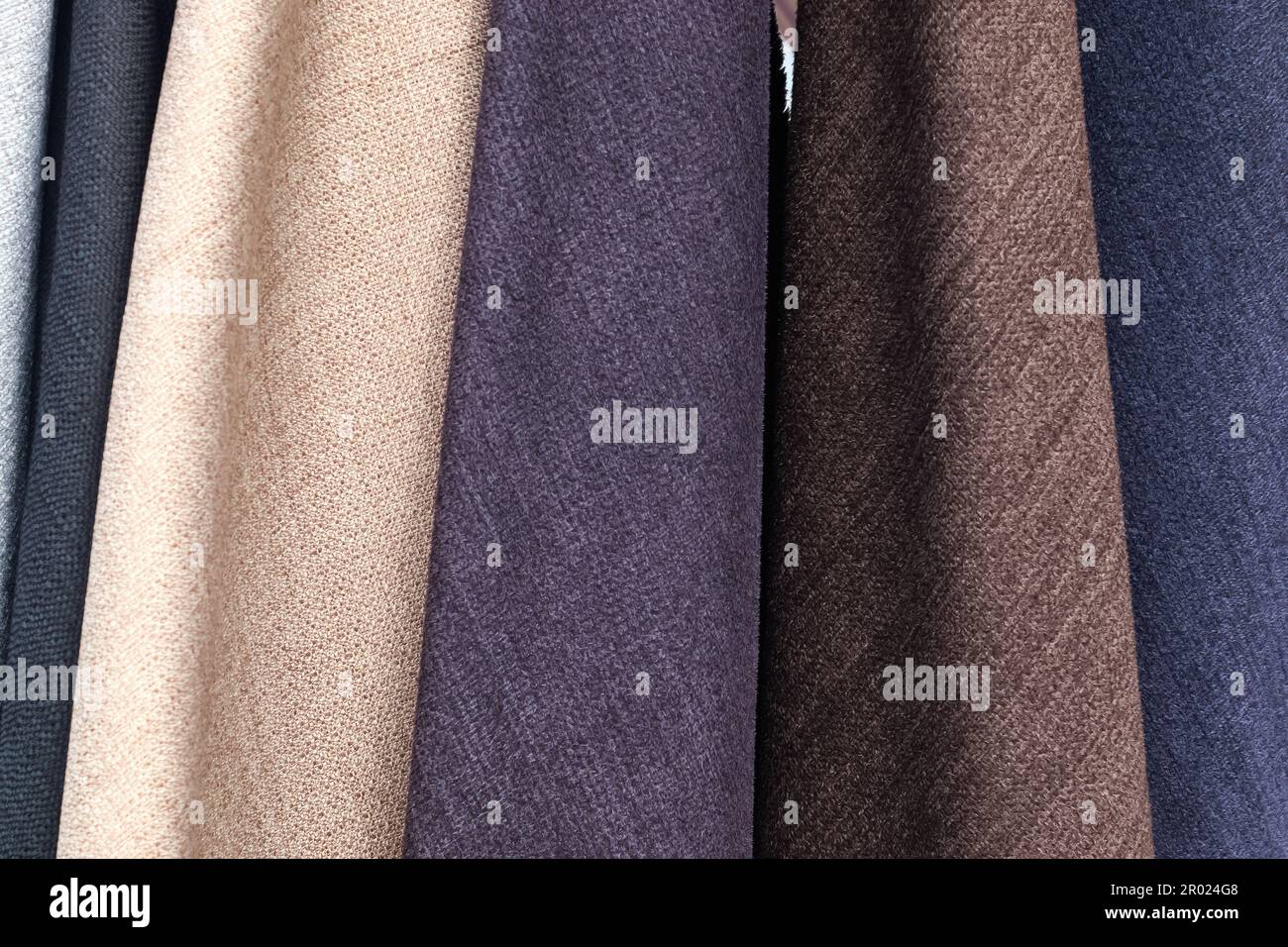 Detailed close up view on samples of cloth and fabrics in different colors found at a fabrics market. Stock Photo
