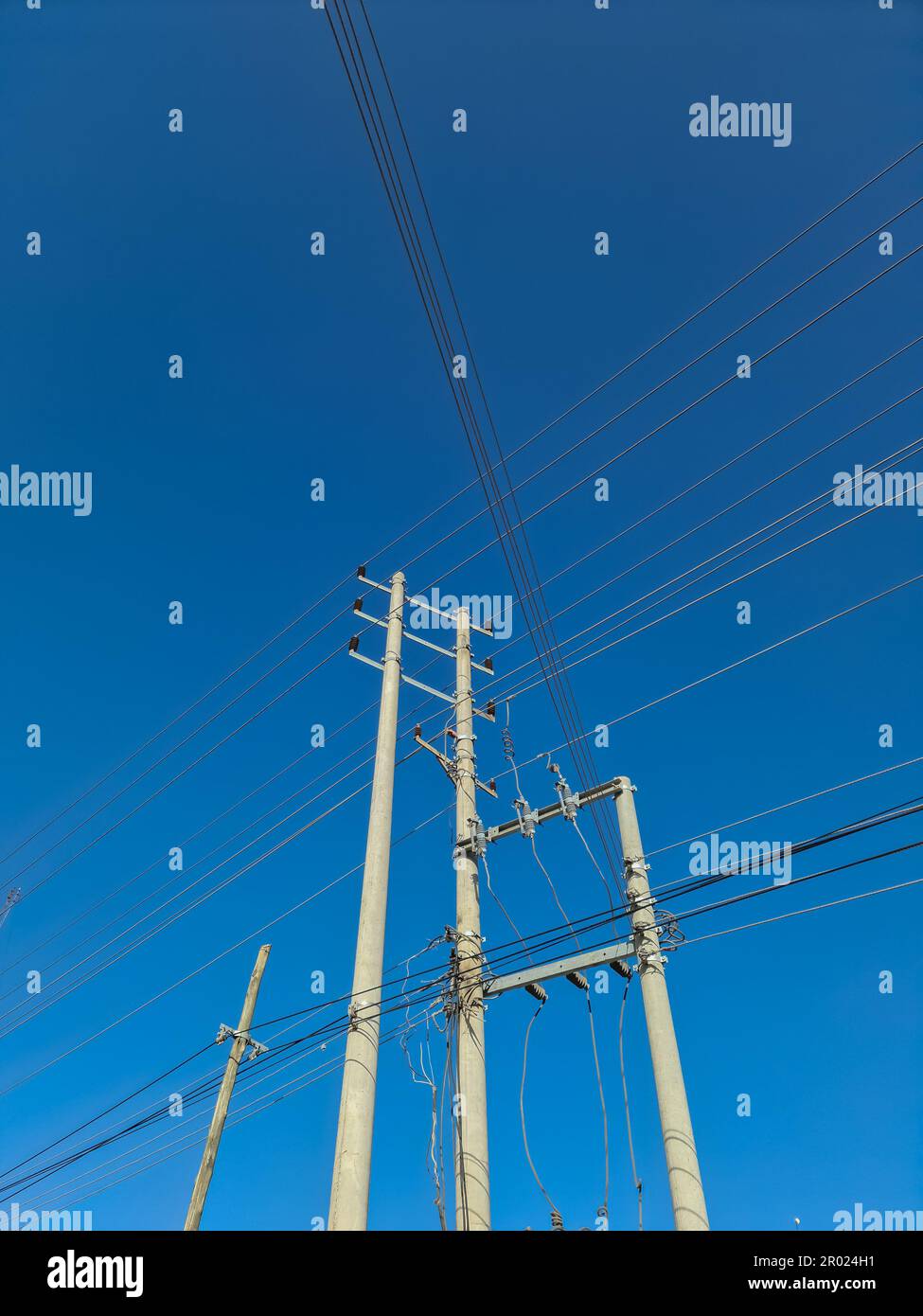 Wildly attached power cables to a power pole Stock Photo