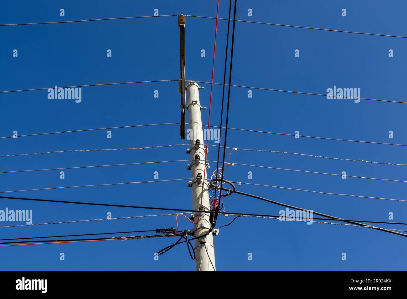 Wildly attached power cables to a power pole Stock Photo