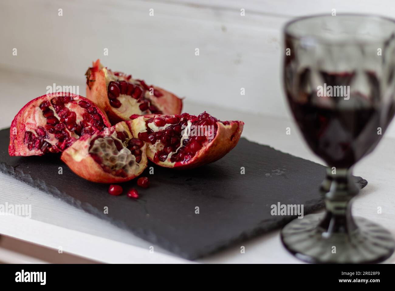 https://c8.alamy.com/comp/2R028F9/pomegranate-with-glass-of-wine-on-table-cut-pomegranate-with-seeds-and-red-wine-fruits-and-wine-summer-still-life-alcohol-drinks-and-ripe-fruits-2R028F9.jpg