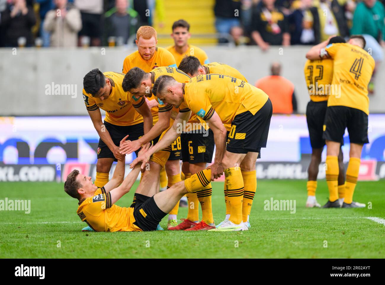 Dresden, Germany. 06th May, 2023. Soccer: 3. league, SG Dynamo Dresden - SV Wehen Wiesbaden, 35. matchday, Rudolf-Harbig-Stadion. Dynamo's Niklas Hauptmann (l) celebrates after his goal to make it 2:1 and has to be treated by his teammates for a cramp in his leg. Credit: Robert Michael/dpa/ZB/dpa/Alamy Live News Stock Photo