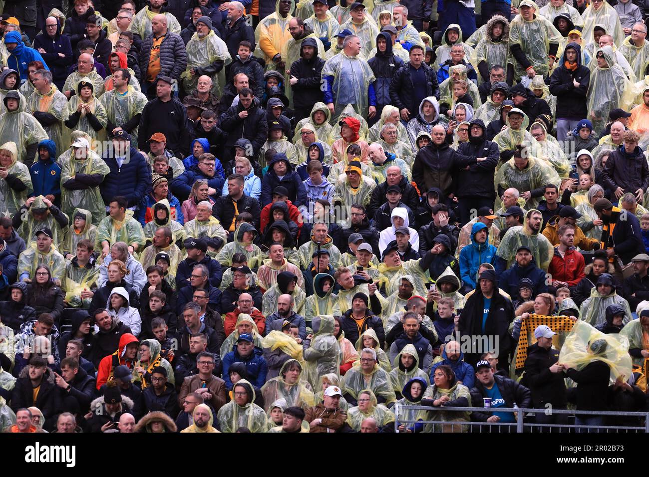 Fans struggle to put on ponchos in rain 