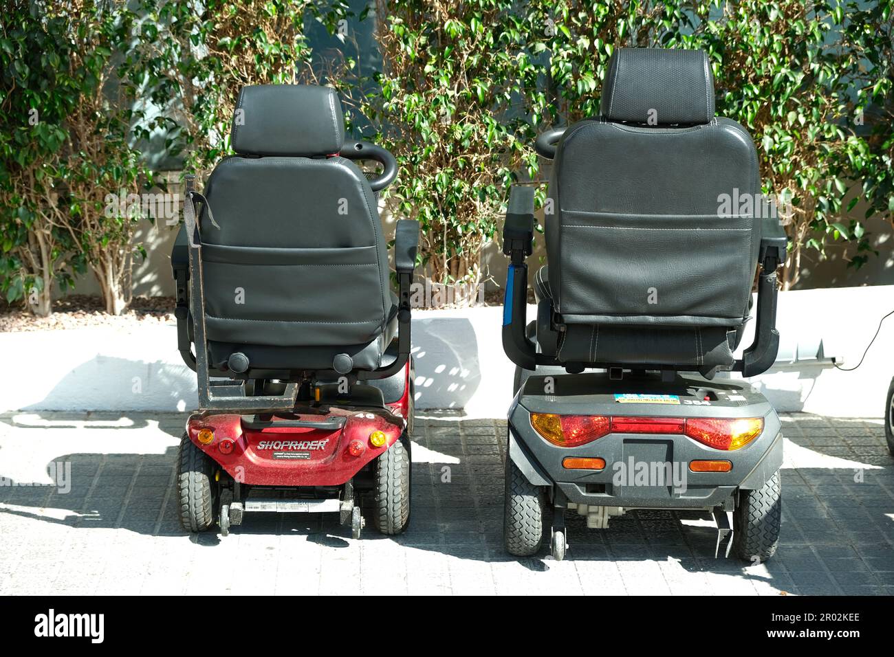 Benidorm, Spain - May 01, 2023: Four wheel mobility electric scooters charging up. Personal transport for seniors or people with disability Stock Photo