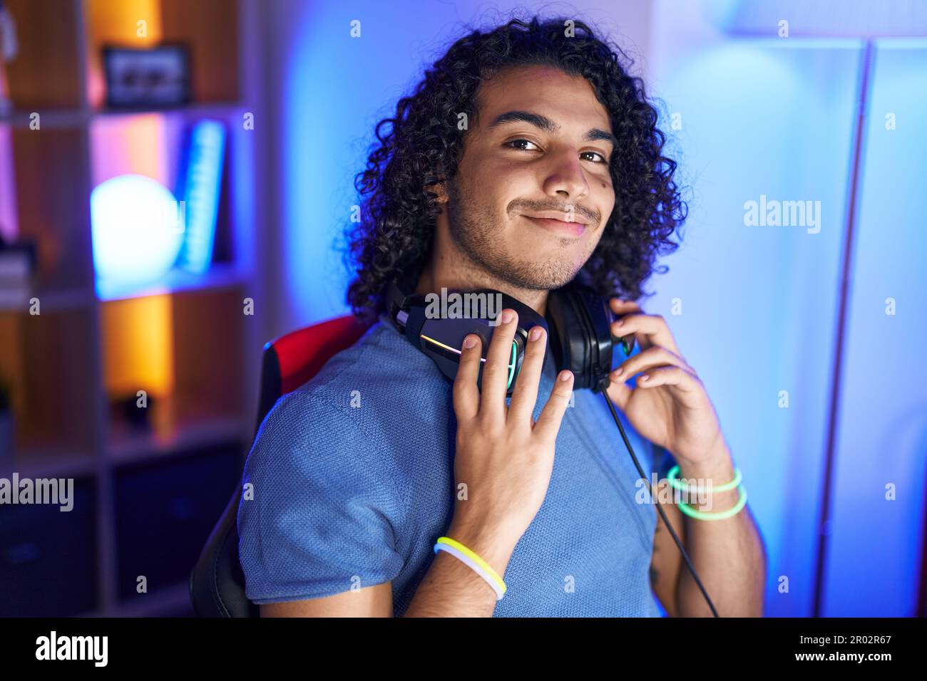 Young latin man streamer smiling confident sitting on table at gaming ...
