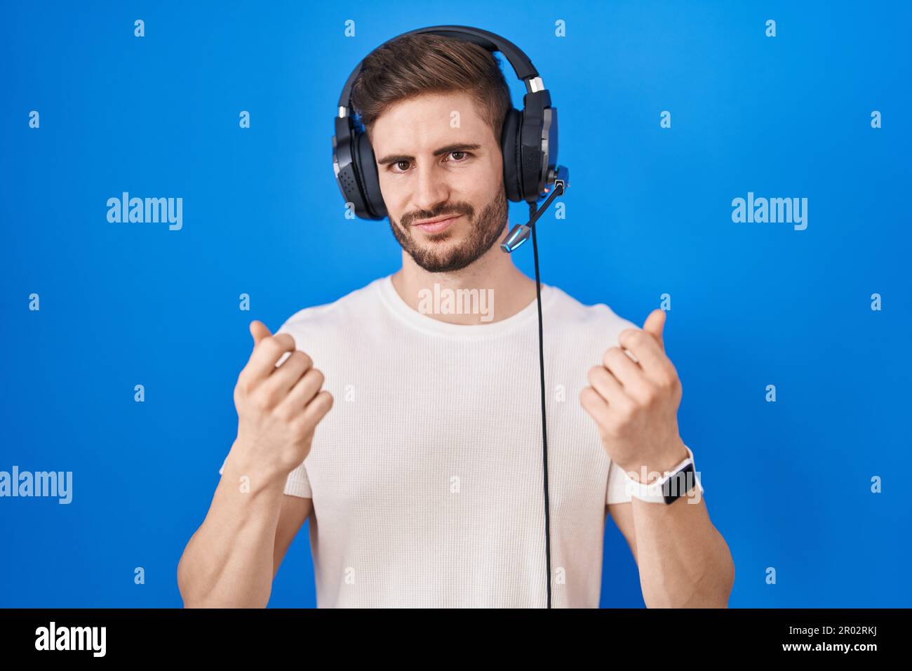 Hispanic man with beard listening to music wearing headphones doing