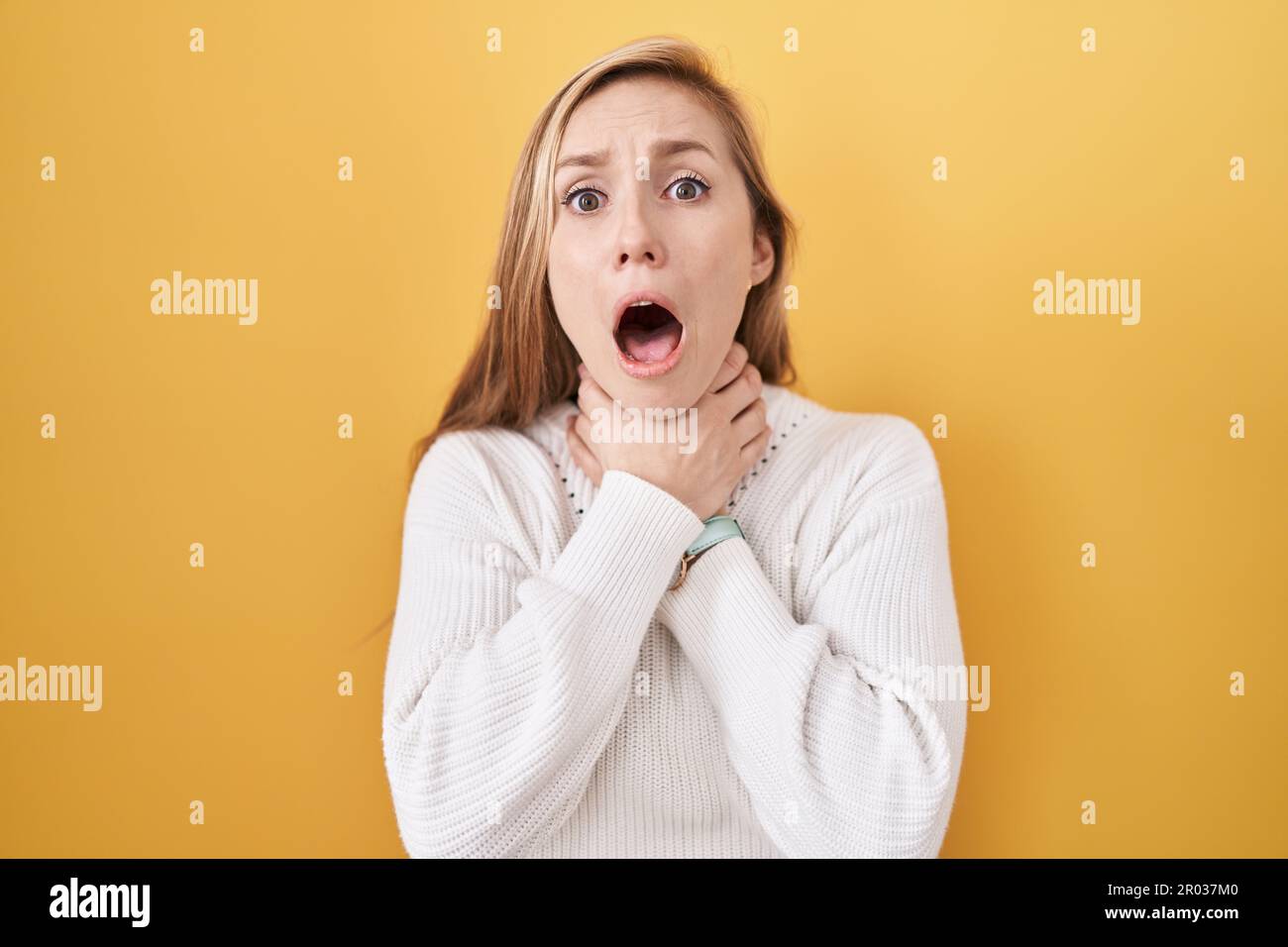 Young caucasian woman wearing white sweater over yellow background ...