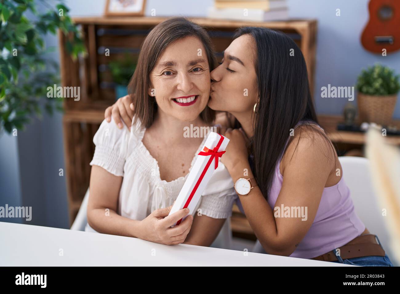 Two women mother and daughter surprise with gift at home Stock Photo — free download