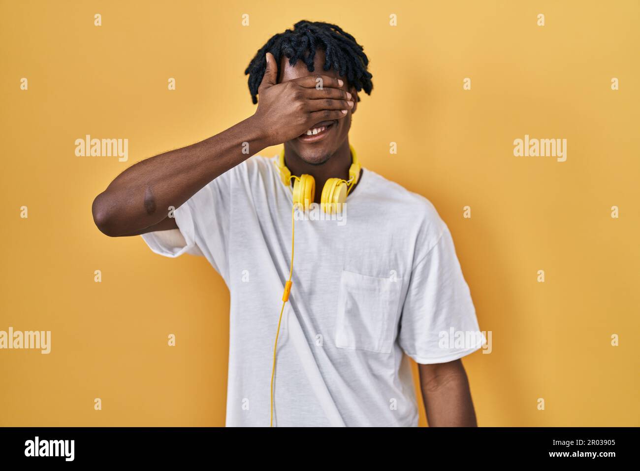 Young african man with dreadlocks standing over yellow background ...