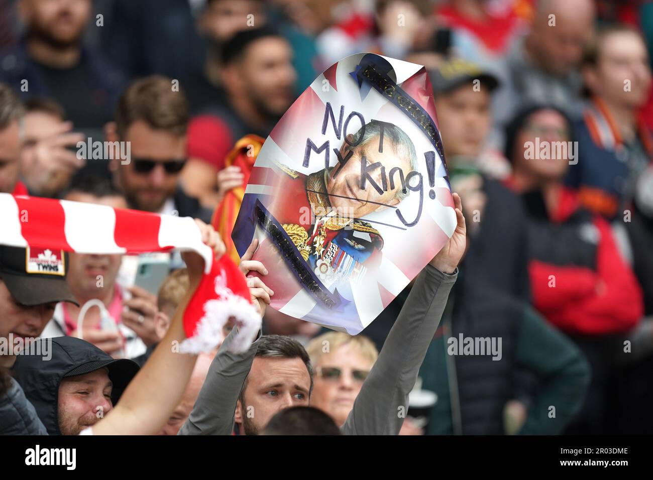 Liverpool fans hold up a sign saying 'Not My King' while booing the