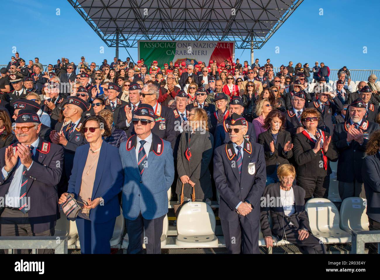Spectators from the grandstand watch the performance of the Carabinieri on horseback during the carousel for the gathering of the National Carabinieri Association. Historic Carousel of the 4th Carabinieri Regiment on Horseback in Ostia Lido to inaugurate the 25th National Gathering of the National Carabinieri Association (ANC). The event, which returns after a 4-year break, thanks to Covid, was organized by the Association, established in 1886, which brings together carabinieri on duty, on leave and their family members, has over 180 thousand members, 250 group volunteers and 164 civil protect Stock Photo