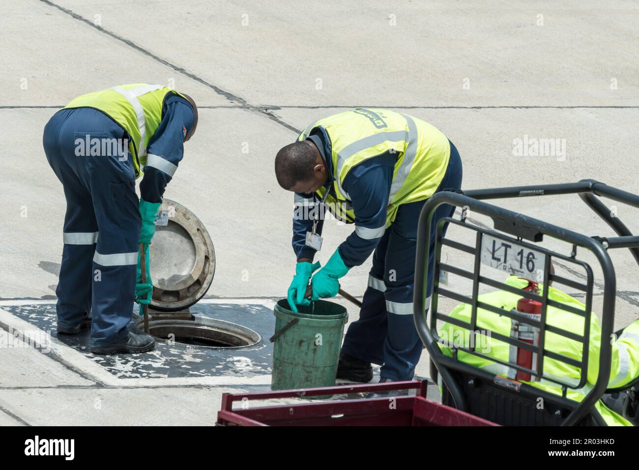 Lanseria airport personnel or employees in Johannesburg, Gauteng, South Africa work cleaning a fuel tank in overalls and high visibility clothing Stock Photo