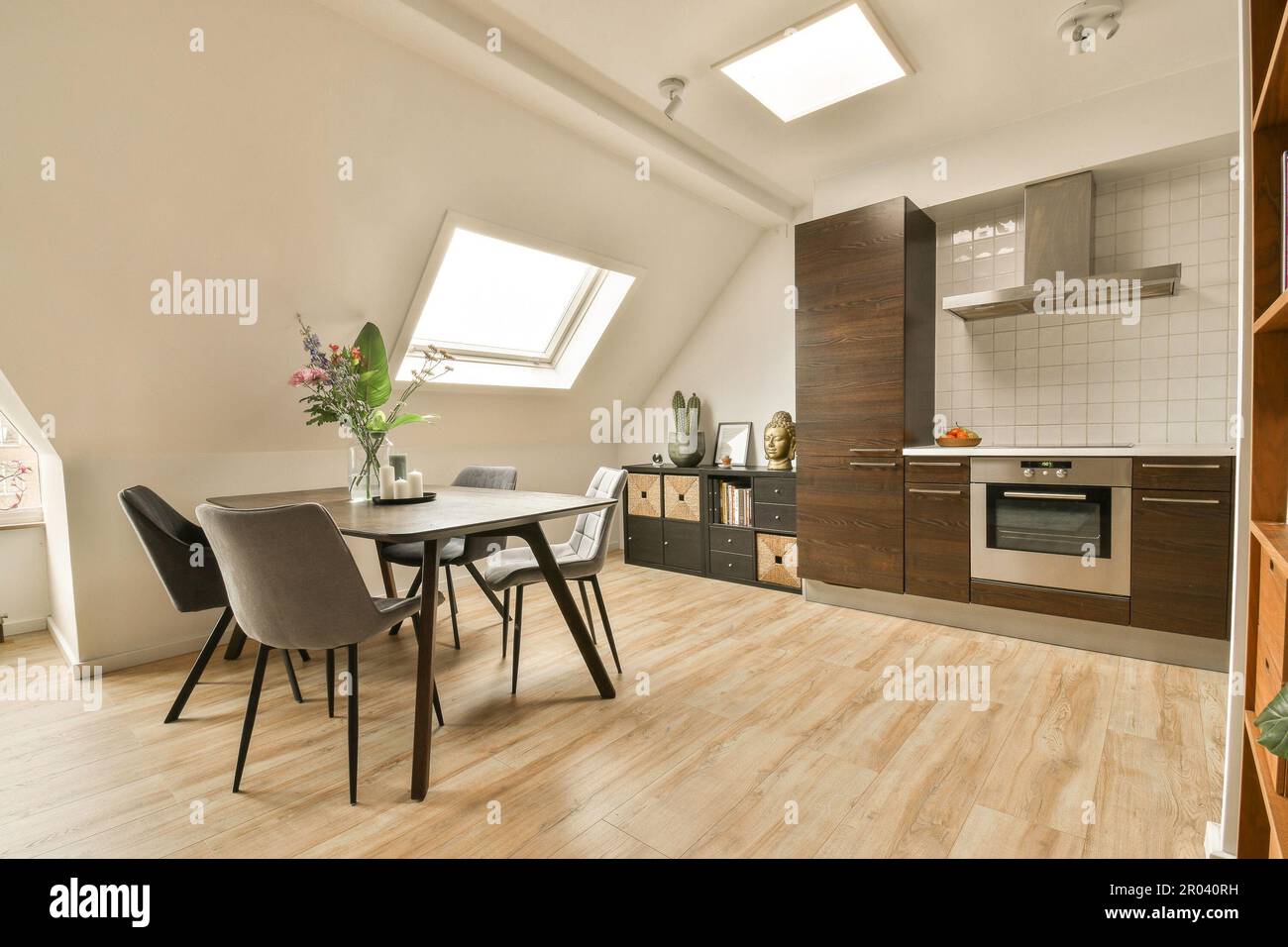 a kitchen and dining area in a room with wood floors, white walls, and ...