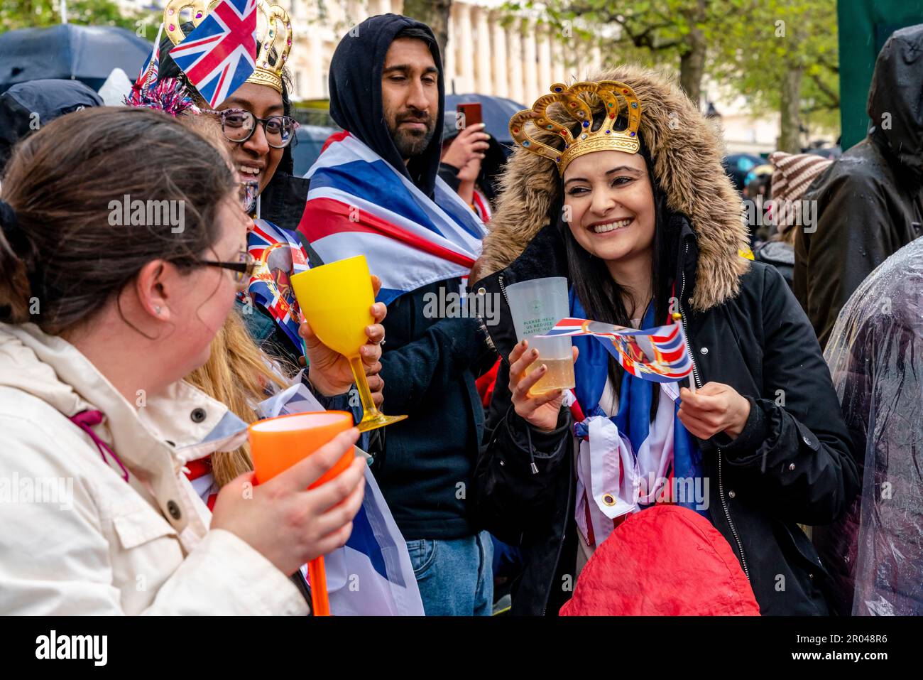 London, UK. 6th May, 2023. A group of young people standing in the Mall toast King Charles III upon his Coronation. Credit: Grant Rooney/Alamy Live News Stock Photo