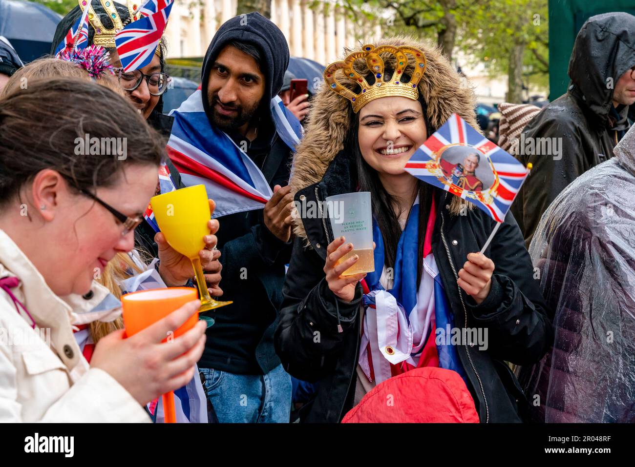 London, UK. 6th May, 2023. A group of young people standing in the Mall toast King Charles III upon his Coronation. Credit: Grant Rooney/Alamy Live News Stock Photo