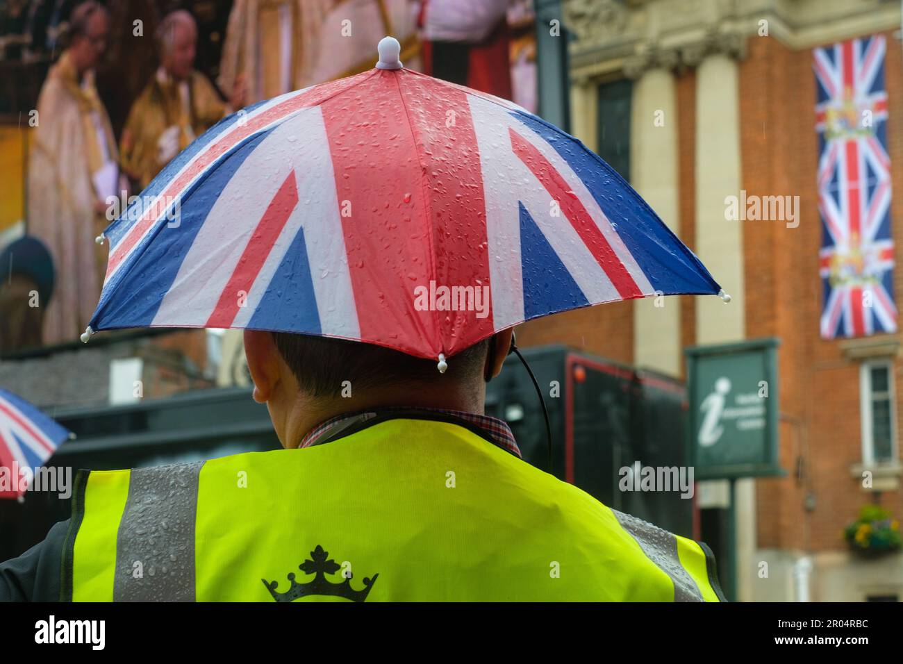 Celebrating the Coronation of King Charles III in front of the big screen in the pouring rain in Henley-on-Thames market square. Stock Photo
