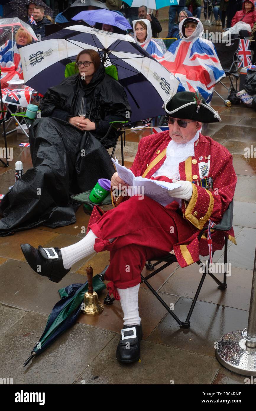 Celebrating the Coronation of King Charles III in front of the big screen in the pouring rain in Henley-on-Thames market square. Stock Photo