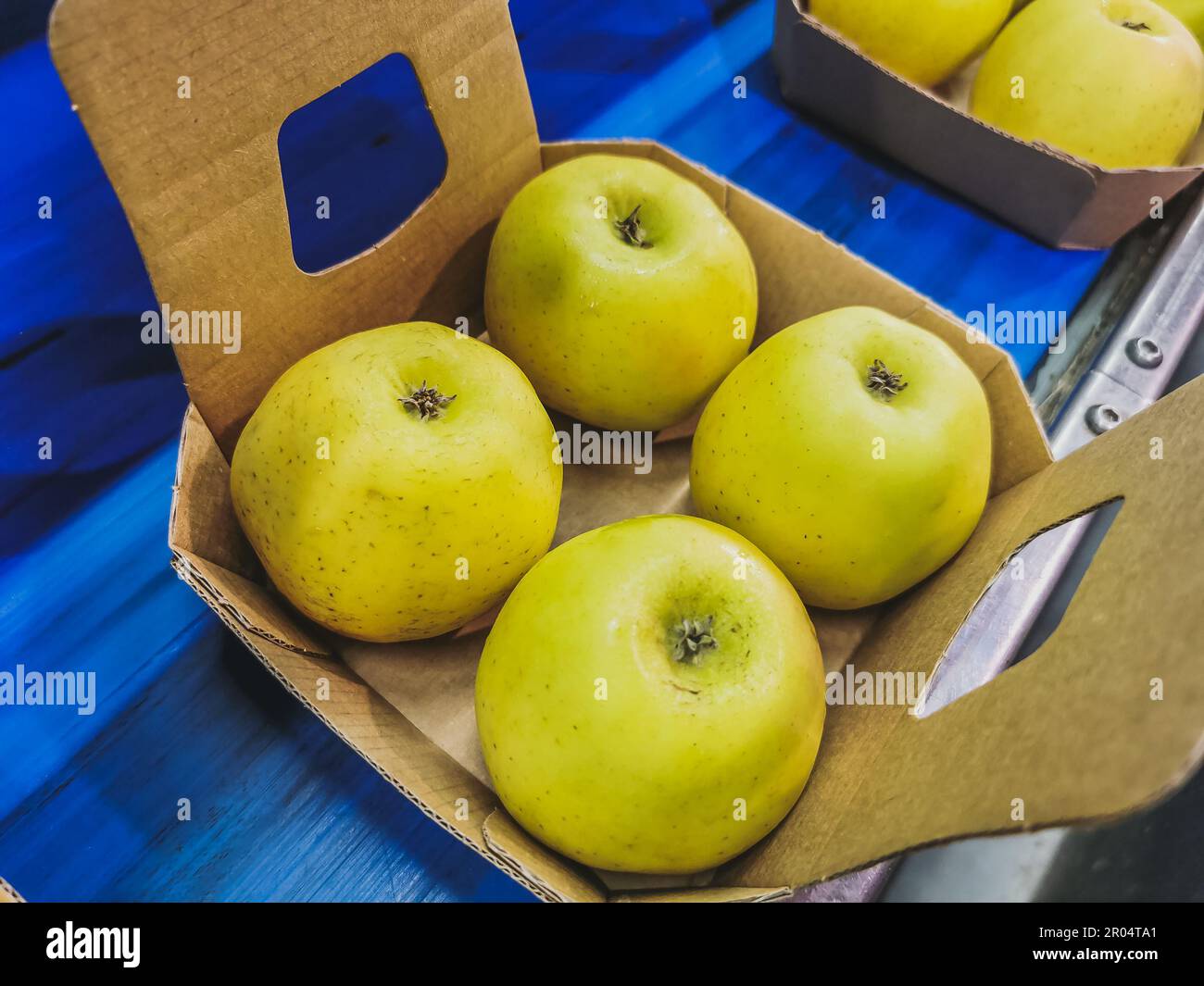Boxes of golden delicious apples on the conveyor belt ready for packing