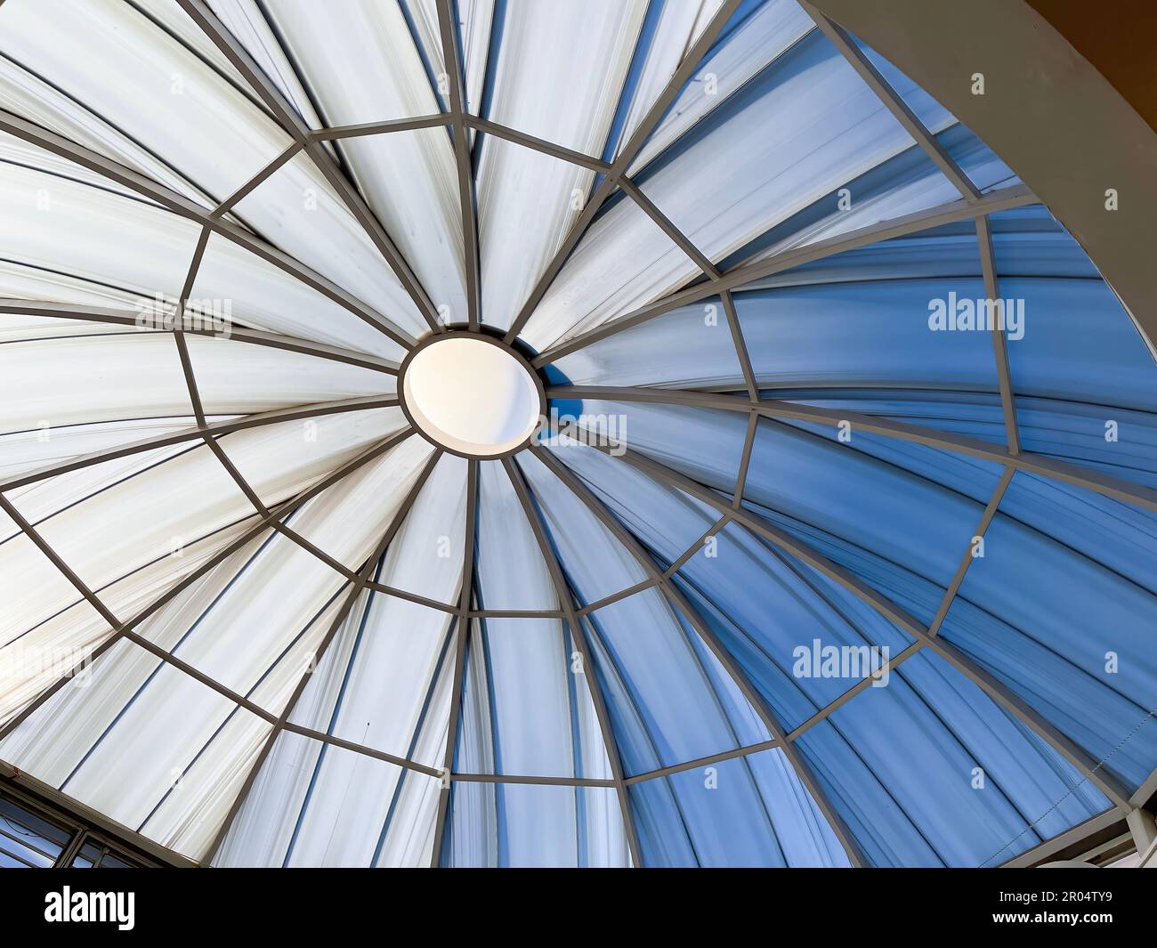 a large skylight dome, with radial structure, large rooflight with slashes coming from the center outward, blue and white tones horizontal Stock Photo
