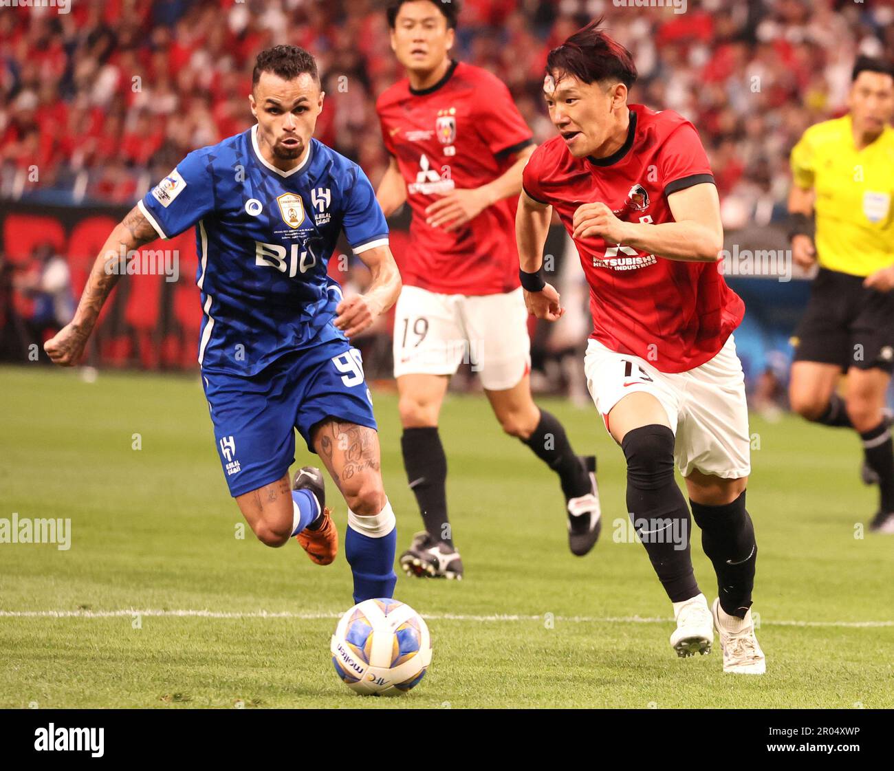 Al Hilal's Ali Al Bulayhi, right, fights for the ball with Urawa