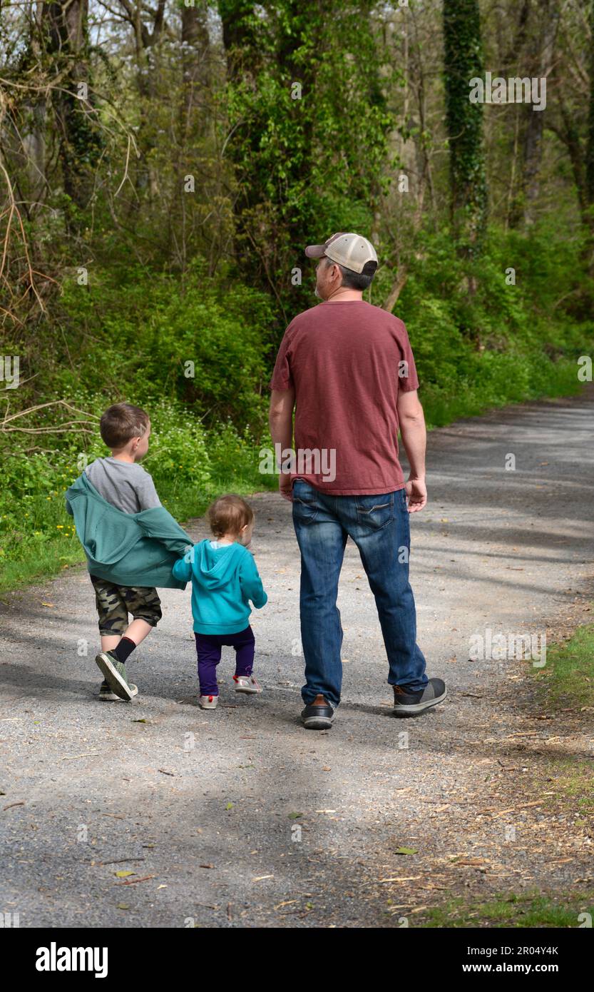 A father and his two young sons walk along the public Virginia Creeper Trail in Abingdon, Virginia. Stock Photo