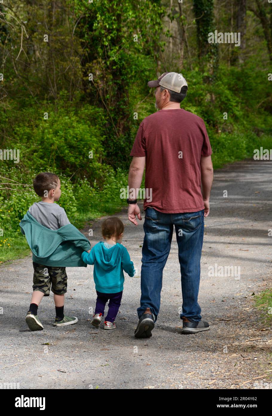 A father and his two young sons walk along the public Virginia Creeper Trail in Abingdon, Virginia. Stock Photo