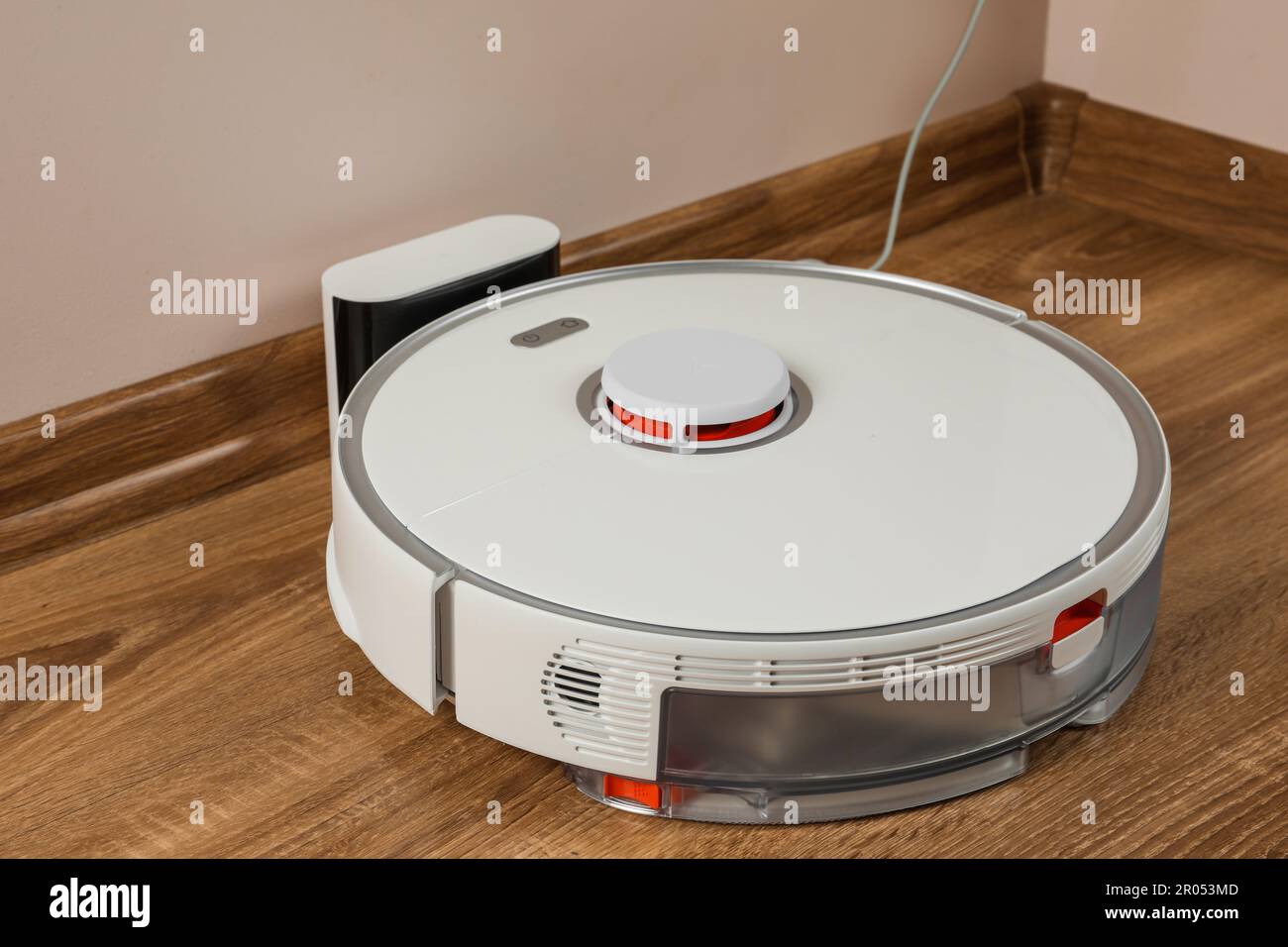 Robotic vacuum cleaner charging on wooden floor indoors Stock Photo Alamy
