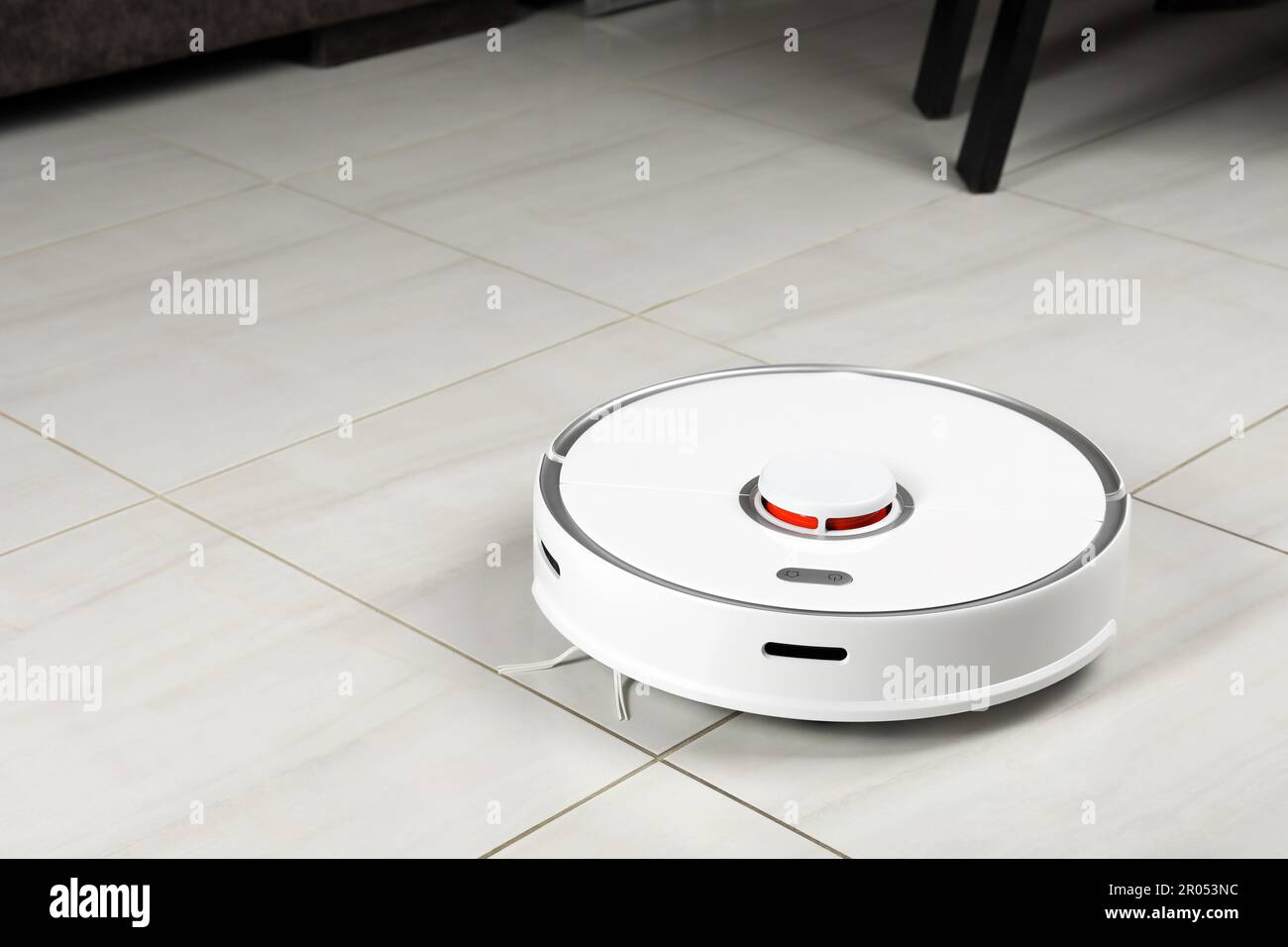 Robotic vacuum cleaner on white tiled floor indoors, space for text