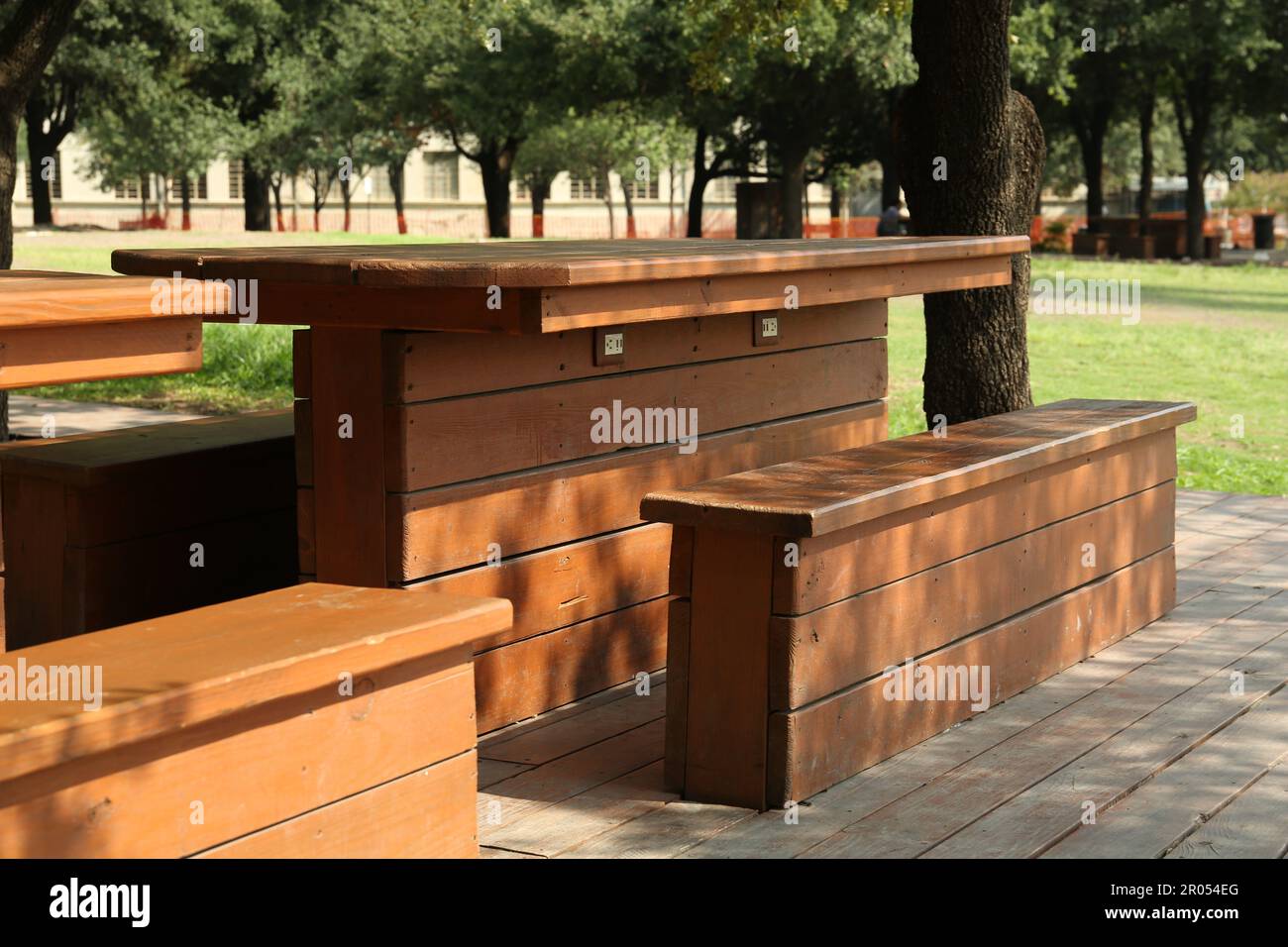 Empty wooden tables with benches in park Stock Photo - Alamy