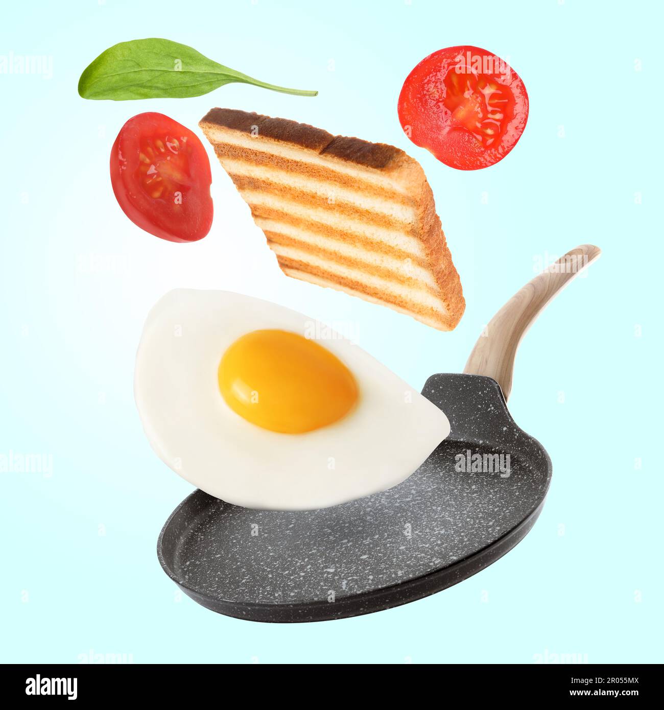 https://c8.alamy.com/comp/2R055MX/tasty-fried-chicken-egg-tomato-toasted-bread-and-basil-leaf-falling-into-frying-pan-on-color-background-2R055MX.jpg