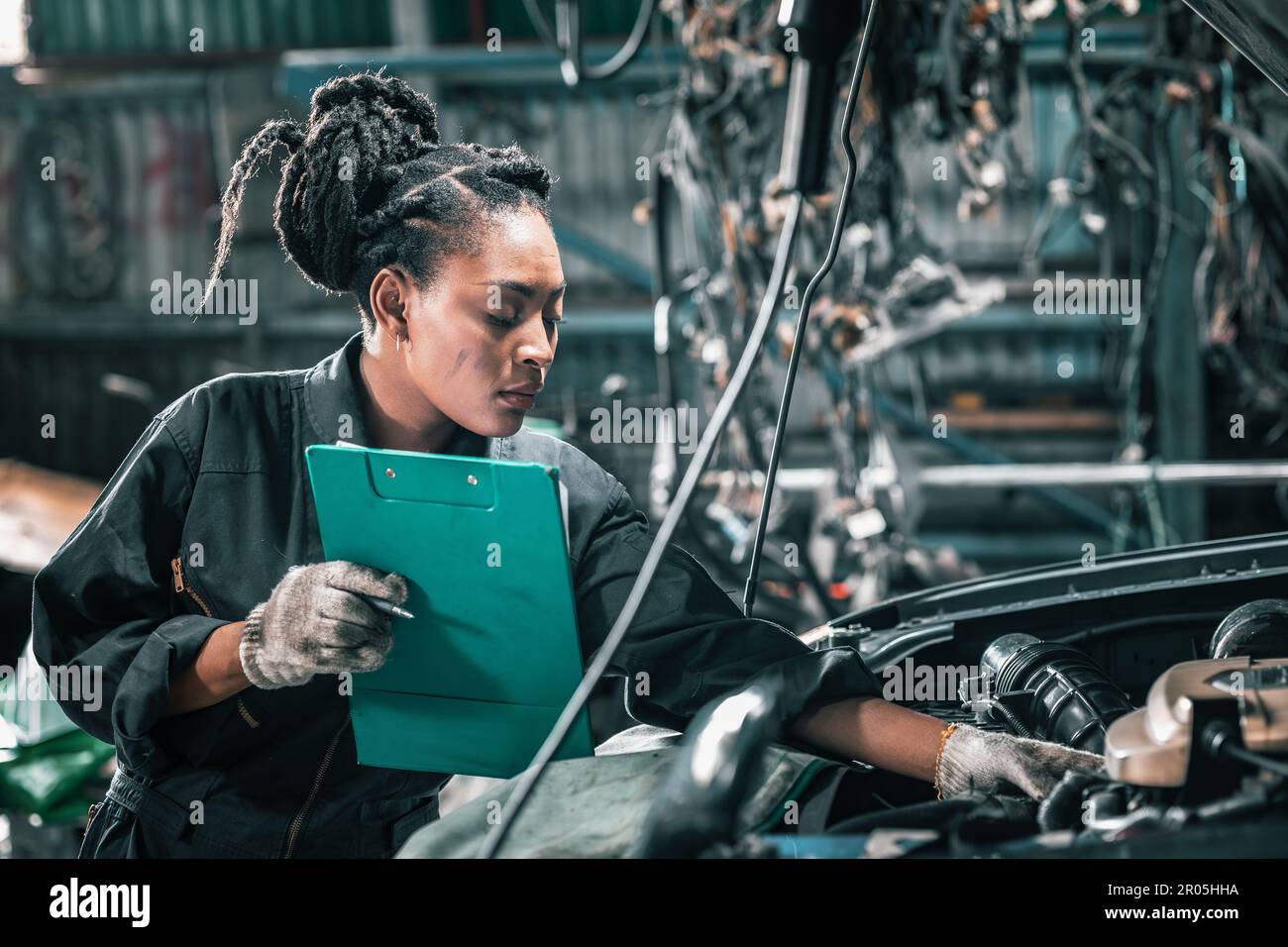 Experienced auto mechanics inspect car battery terminals and voltage to