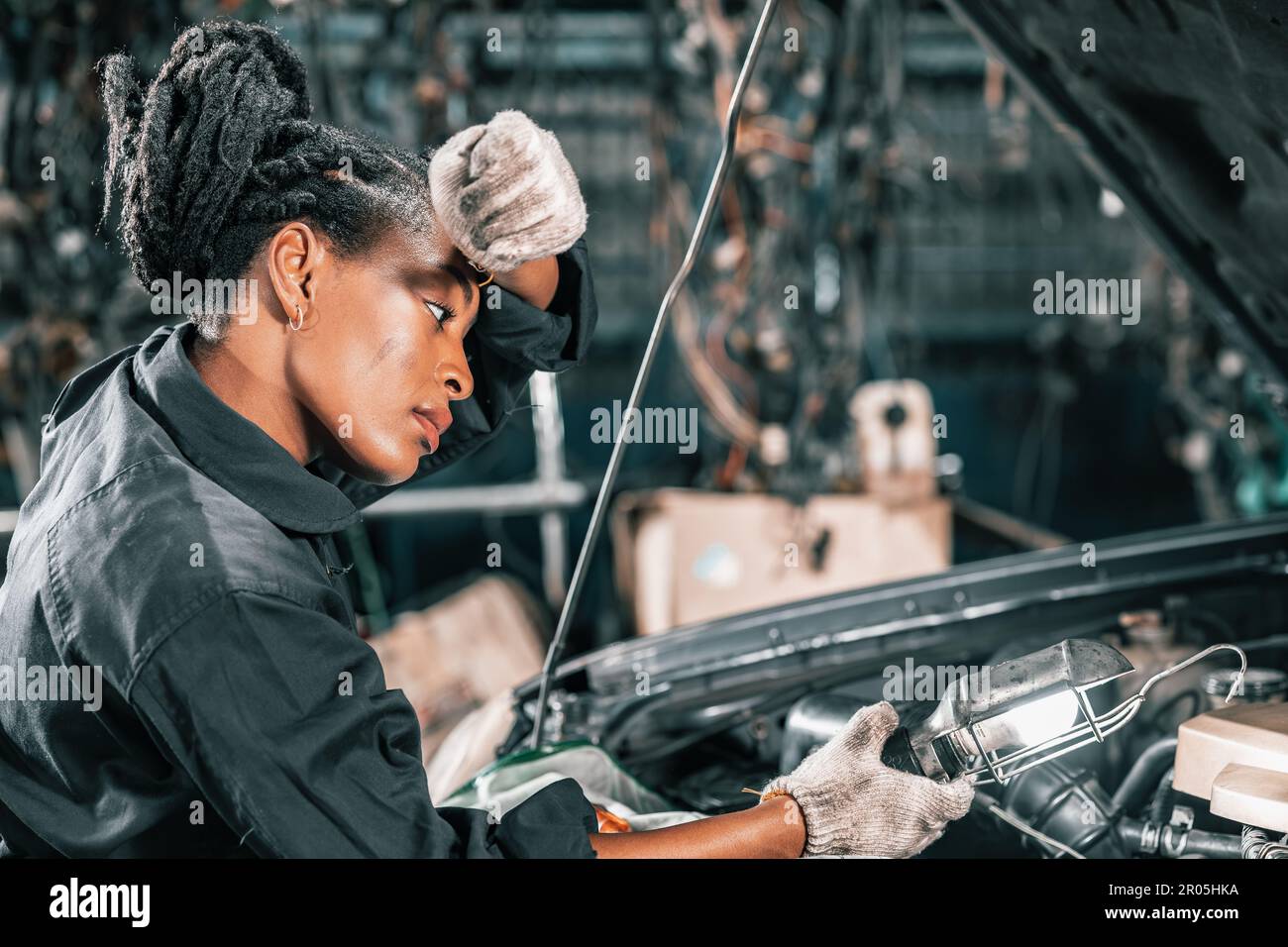 Experienced auto mechanics inspect car battery terminals and voltage to