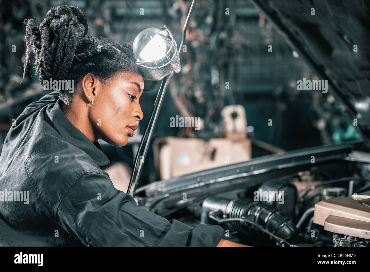 Experienced auto mechanics inspect car battery terminals and voltage to