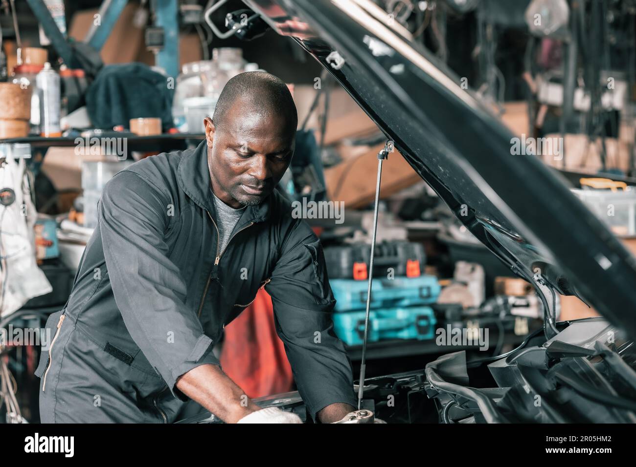 Experienced auto mechanics inspect car battery terminals and voltage to