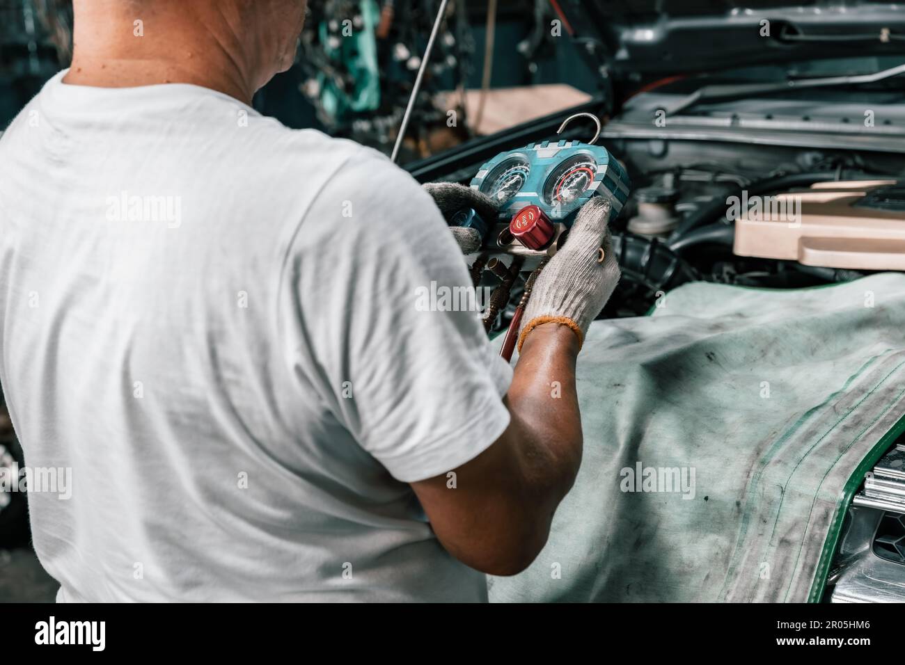 Experienced auto mechanics inspect car battery terminals and voltage to