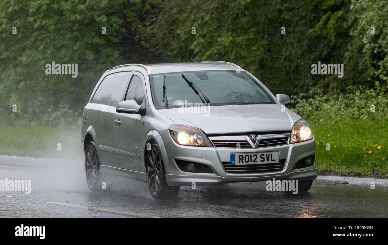 Stony Stratford,Bucks,UK - May 6th 2023. 2012 silver VAUXHALL ASTRA  driving in the rain on a wet road Stock Photo