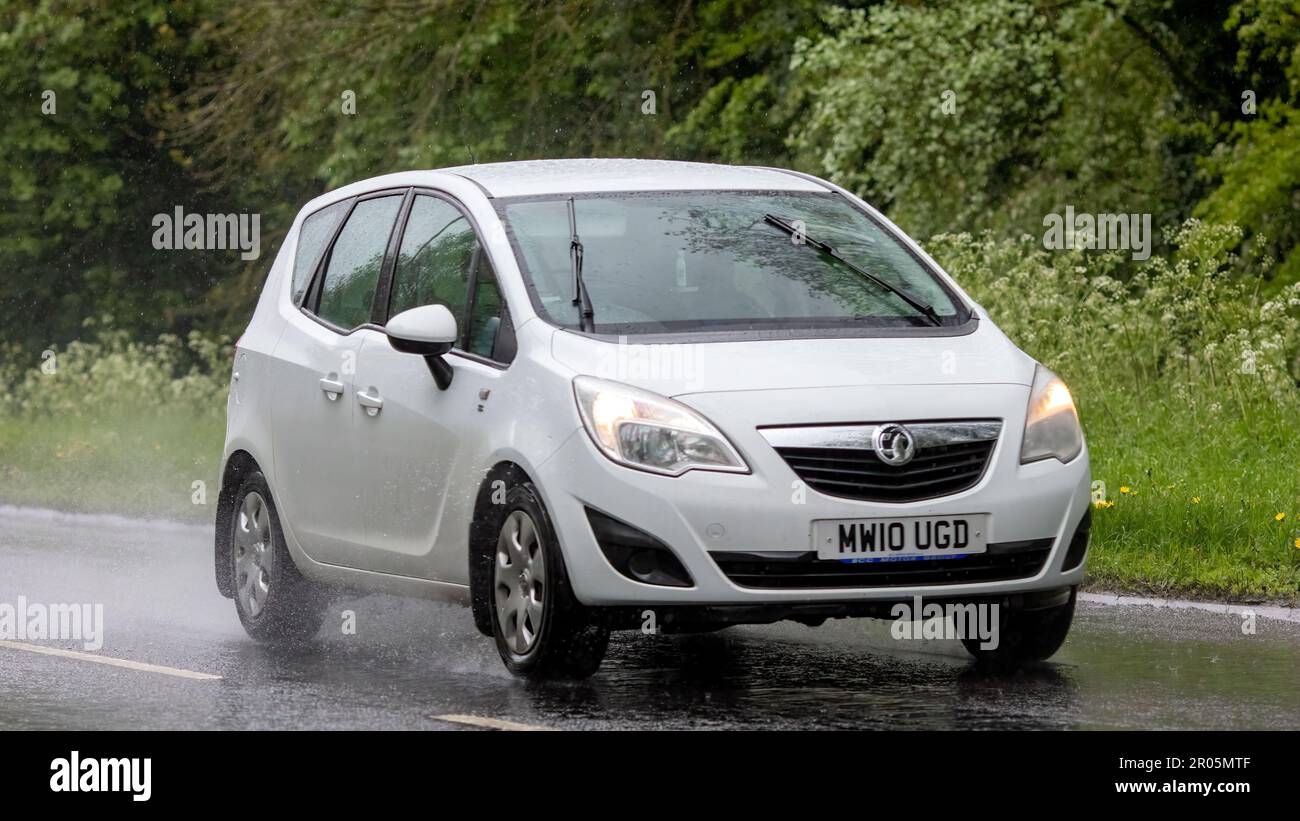 Stony Stratford,Bucks,UK - May 6th 2023. 2010 white VAUXHALL MERIVA driving in the rain Stock Photo