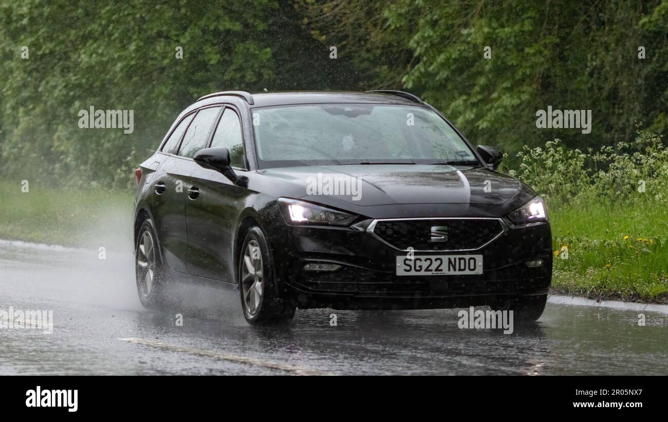 Stony Stratford,Bucks,UK - May 6th 2023. 2022 black SEAT LEON driving in the rain on a wet road Stock Photo